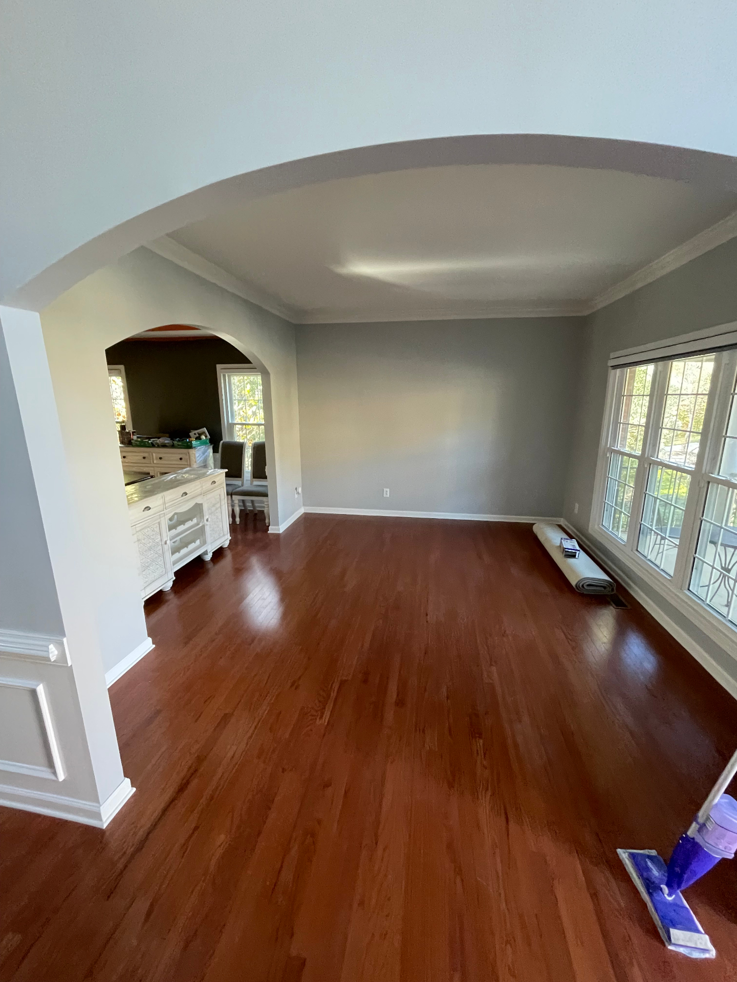 Living room with arched opening, gray walls, and refinished cherry hardwood floors